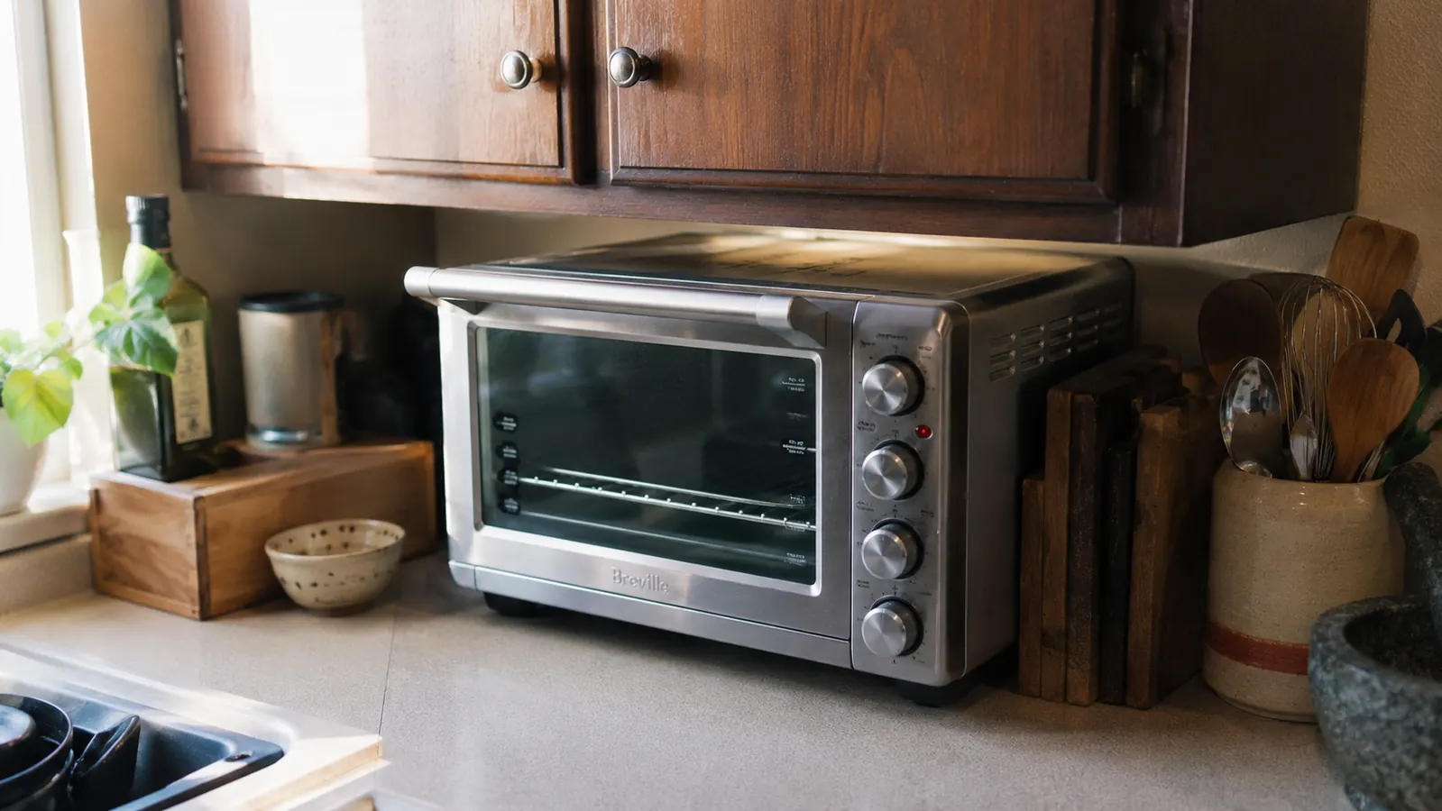 Close view of the toaster oven tucked under an upper cabinet with a couple inches of clearance